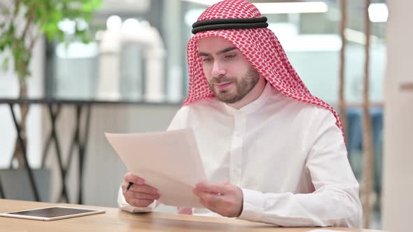 Hardworking Arab Businessman Reading Documents in Office 