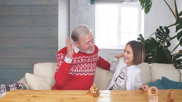Happy Grandfather Playing Games with His Granddaughter Indoors