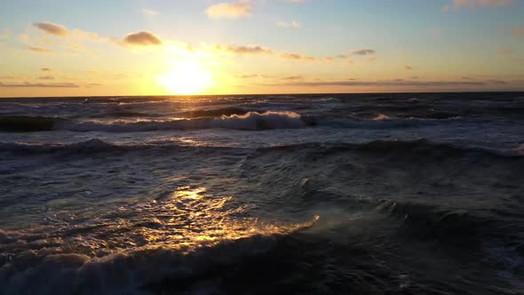 Endless Sea with Large Waves Against Sky with Clouds and Sun