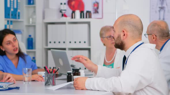 Doctor Checking List of Patients During Medical Conference