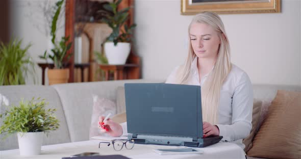 Businesswoman Working on Laptop on a Project at Home Office