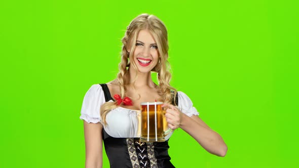 Girl in Bavarian Costume Is Luring Someone for a Glass of Beer. Green Screen