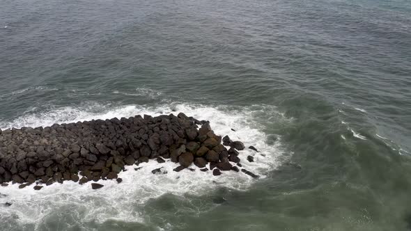 Breaker rocks in Atlantic Ocean in Vik, Iceland with drone video pulling out.