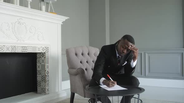 Afro American Man Writing on a Piece of Paper