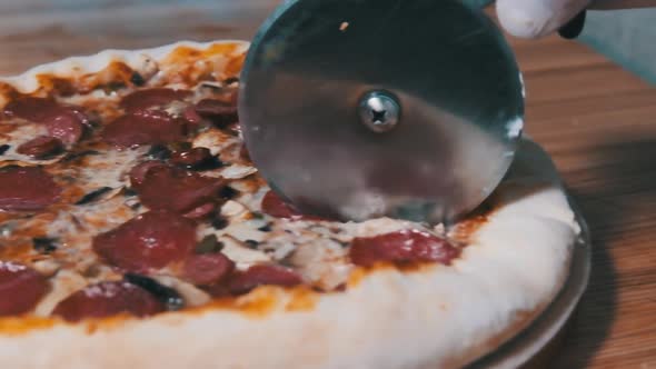 Cutting Pizza with a Round Cutter Knife. Slow Motion 240 Fps