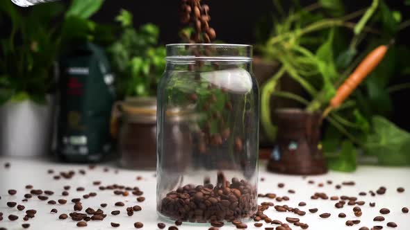 Slow Motion Empty Transparent Jar Filled with Coffee Beans on White Table with Coffee Beans Lay on