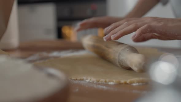 Female Hands Rolling out Dough with Rolling Pin