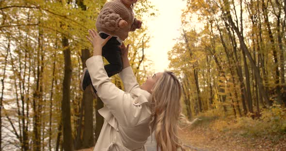 Young Mother with Her Daughter in the Autumn Park