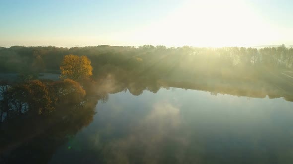 Foggy Sunrise Over Park Alley By the Lake