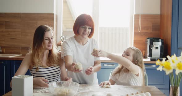 Mother Daughter and Grandmother Baking Cooking Together in the Kitchen at Home