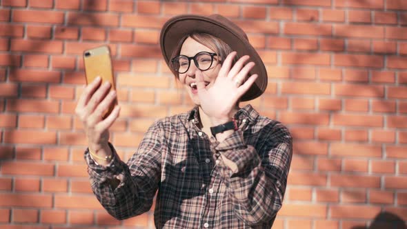 An Attractive Cheerful Woman Taking a Video Call with Her Smartphone