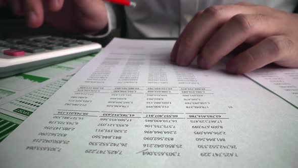 Accountant Analyzing Business Marketing Data on Paper Dashboard at Office Table