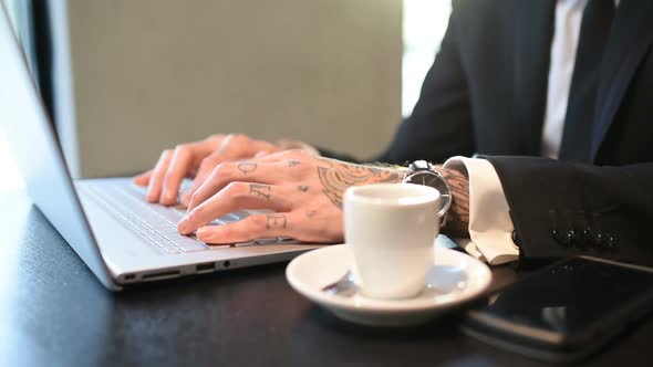 close up tattooed hand young businessman using computer