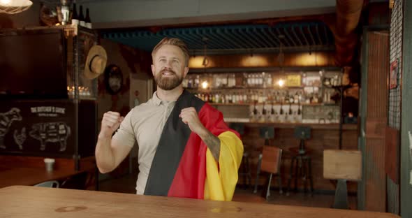 Man with the Flag of the National Country of Germany Watching Sport Game