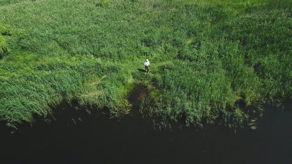 A Fisherman On The Shore Of The Lake Catches Fish On A Spinning Rod. Aerial Photography.