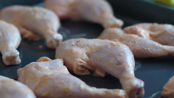 Cooking chicken legs on a baking sheet at home. Raw chicken legs in a frying pan.Selective focus. Fr