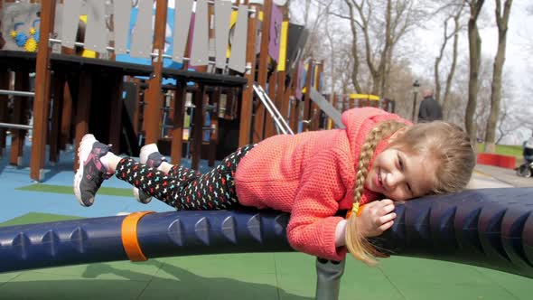 Funny Fair Haired Kid with Plait on Rotating Attraction