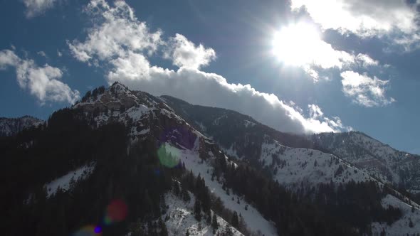 Aerial pan viewing mountain tops and Sun