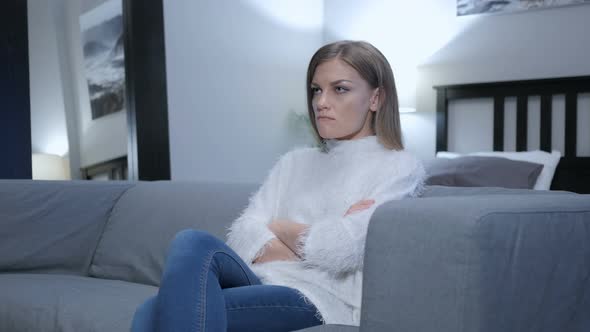 Angry Woman Sitting on Couch at Home