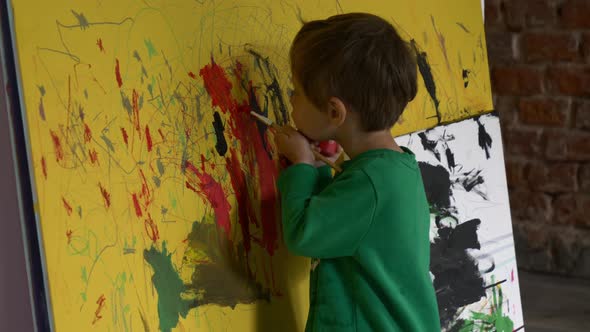 toddler boy is painting on the wall during quarantine