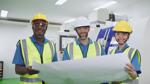 Portrait of interracial male and female worker team working in industry looking drawing at factory.