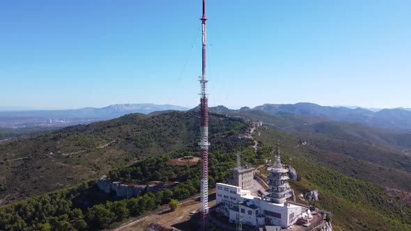 Drone Shot (rotating and close up) of a Radio Station on top of an Arid Hill under a Midday Sun