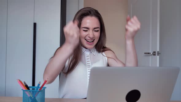 Euphoric Young Student Female Winner Looks at Laptop Celebrates Online Success Sits at Home
