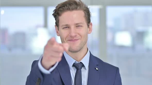 Portrait of Young Businessman Pointing Finger at Camera