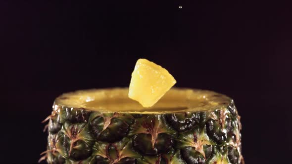 Pineapple Pieces Falling on the Surface of Half Pineapple in Slow Motion