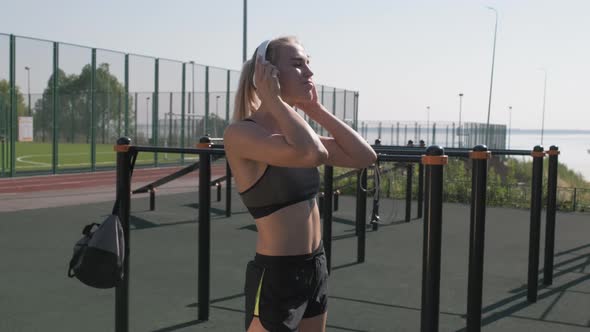 Athletic Girl In Headphones Boxing Outside