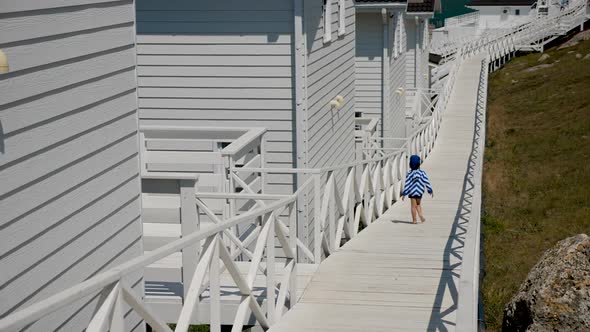 Boy Child in a Striped Blue Jacket and Bandana Walks