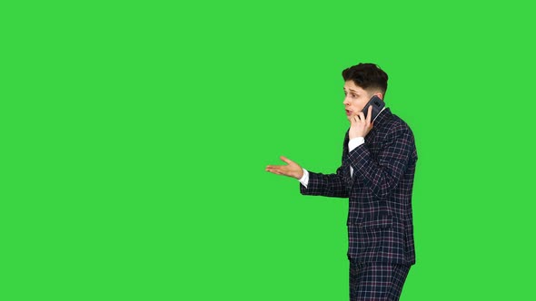 Young Angry Emotional Man in Formal Suit Talking on the Phone and Dancing After on a Green Screen