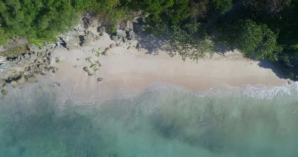 Beautiful aerial shot with drone on a beautiful beach watching the white sand and splash waves, on a