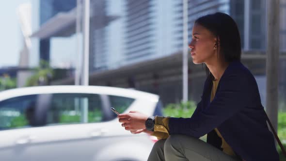 African american woman using smartphone in street