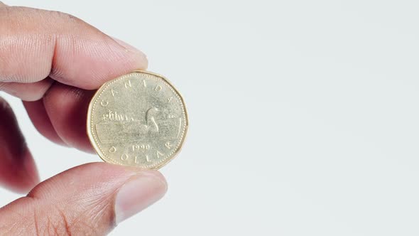 Fingers Hold A Bronze Canada Dollar Coin Front 