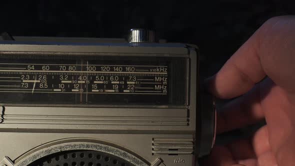 Man Hand Tunes and Catches Radio Wave on Old Radio Tape Recorder