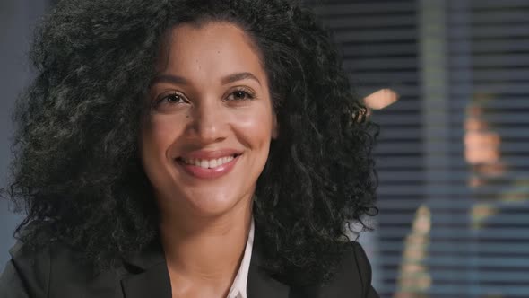 Portrait of African American Woman in a Business Suit Looking Away and Smiling