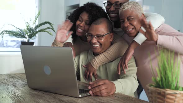 Happy black family having fun doing video call using laptop at home during corona virus outbreak