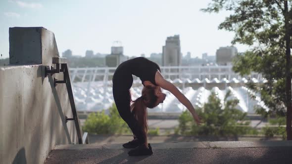 Young Slim Woman Bending Backwards in Urban City. Wide Shot Portrait of Beautiful Slender Caucasian