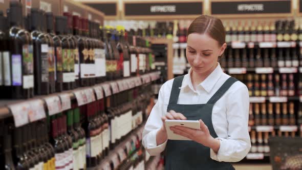 Lady Store Manager Checks Availability of Drinks Closeup