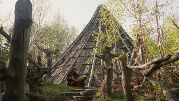 Musicain in Shaman Costume Plays Ritual Drum Near Ail