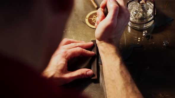 Leather Workshop  a Man Cuts the Piece of Pressed Leather with Hot Solder