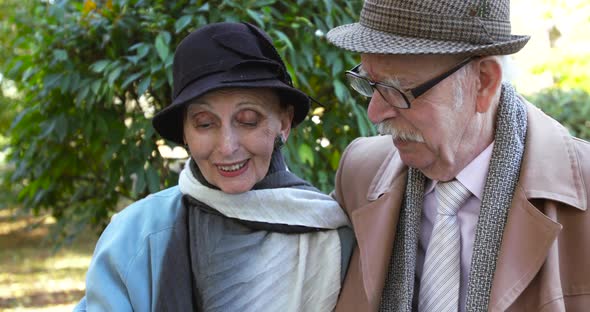 Happy Couple Having Positive Emotions and Talking When Looking Photo Album