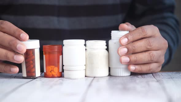 Young Man Hand Holding Many Medicine Pill Container White Sited