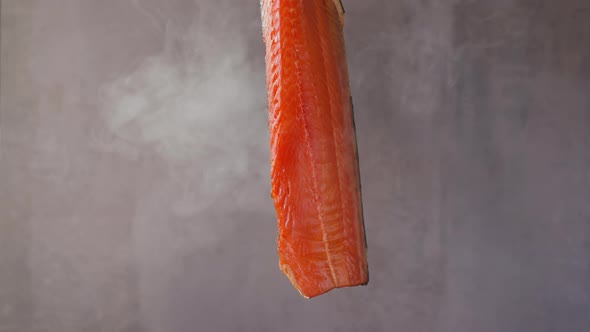 Expensive Cool Smoked Salmon Fillet Hangs Turning in Smoke