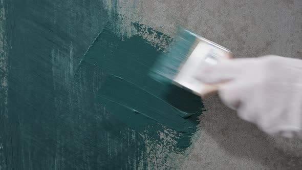 Renovation Painting Walls with Blue Paint Using Brush Closeup