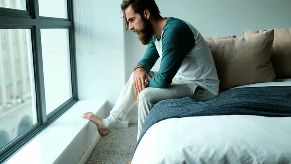 Worried man sitting on a bed 