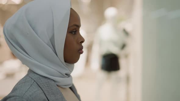 AfricanAmerican Woman with White Hijab Walks Past Stores