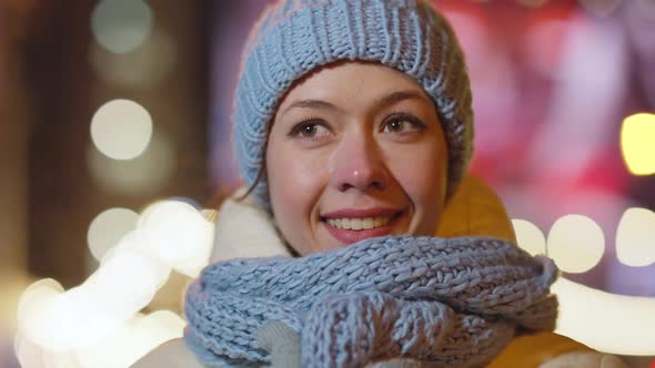 Headshot of Charming Young Caucasian Woman Looking Around Standing Outdoors on Urban Evening with