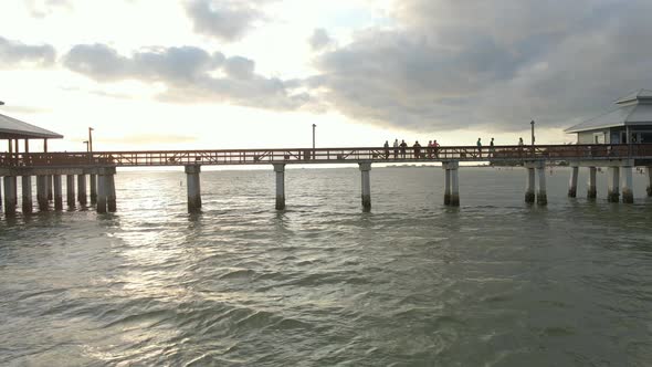 Aerial view people walking at Fort Myers iconic Pier during sunset, Florida